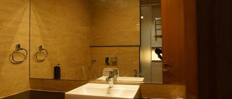 A bathroom with a large mirror, two sinks, and a towel rack.