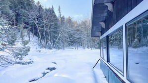 A modern building with large windows overlooking a snowy forest.
