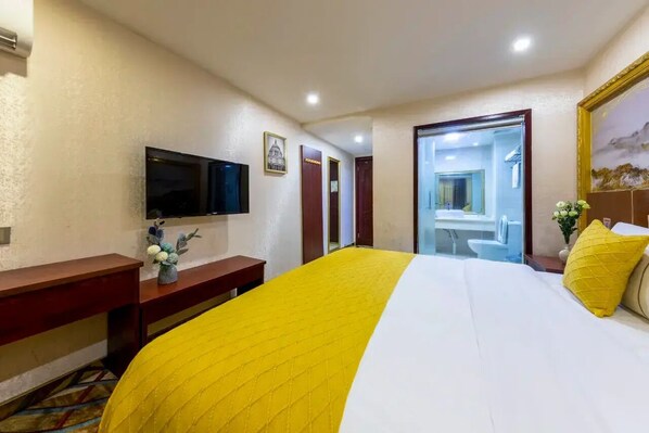 A hotel room with a bed, a television, a desk, and a bathroom visible through an open door. - City-state Boutique Hotel (Shenzhen)