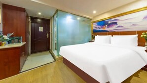 A hotel room with a bed, a desk, a door, and a wall with a painting. - City-state Boutique Hotel (Shenzhen)