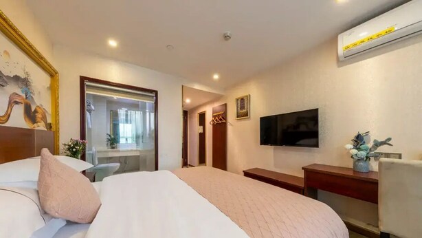 A hotel room with a bed, a desk, a TV, and an air conditioning unit. - City-state Boutique Hotel (Shenzhen)