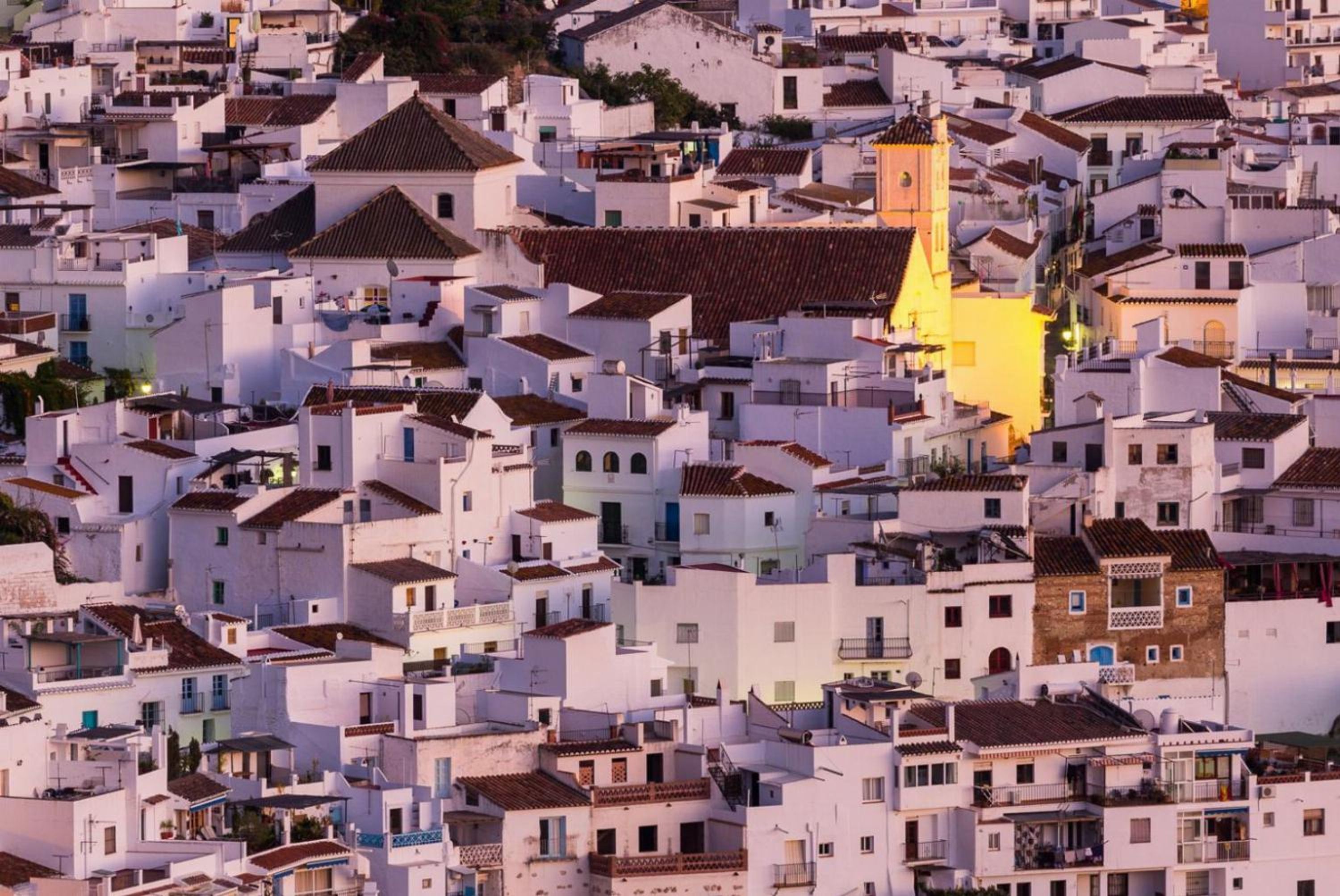 Una zona urbana densa con edificios blancos muy próximos y tejados de tejas rojas.
