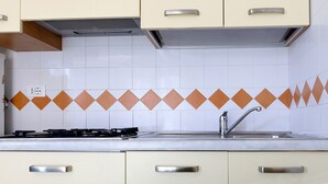 Eine Küche mit Gasherd, Spüle und Schränken.