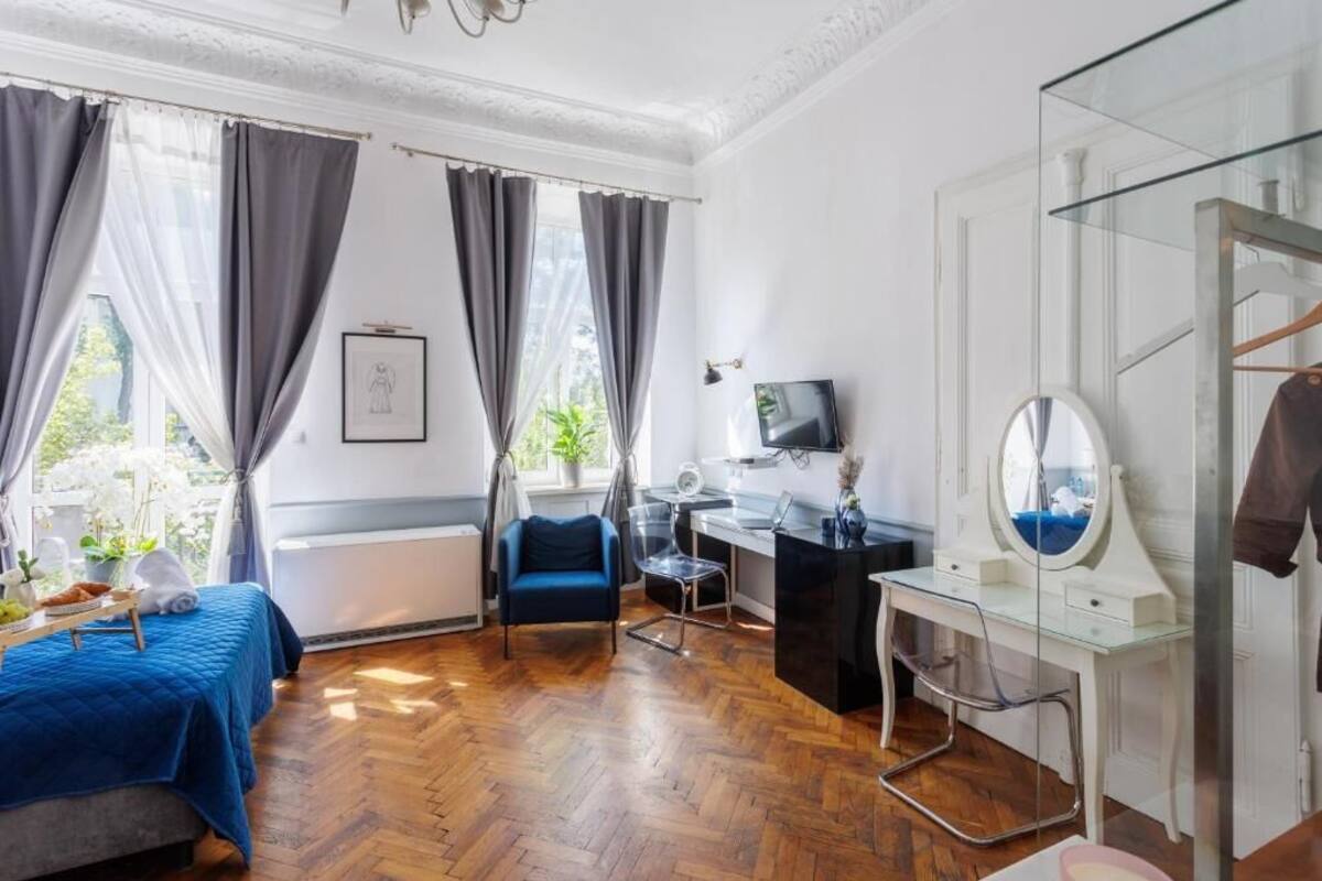 Ein Zimmer mit Bett, Schreibtisch, Stuhl, Fernseher und Spiegel.