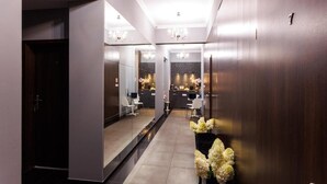 Un vestíbul d'hotel modern amb taulell de recepció, zona de seients i una escala.