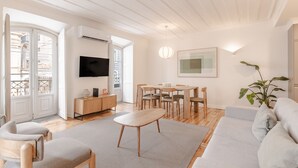 A modern living room with a sofa, chairs, a dining table, and a TV. - C1 Fully Renovated & Modern | Central | A/C (Lisboa ciudad)