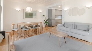 A modern living room with a grey sofa, wooden dining table, and chairs. - C1 Fully Renovated & Modern | Central | A/C (Lisboa ciudad)
