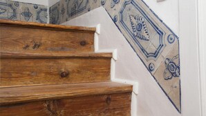 A wooden staircase with white steps and blue decorative tiles on the wall. - C2 Authentic Stay | XVIII Century Charm | DT (Lisboa ciudad)
