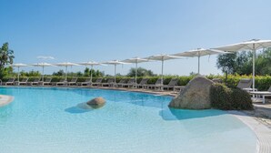 Ein klarer Pool mit Liegestühlen und Sonnenschirmen.