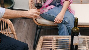 A wicker chair with a bottle of wine and a smartphone on a table. - BE Fully Renovated | Central | Private Patio (Lisboa ciudad)