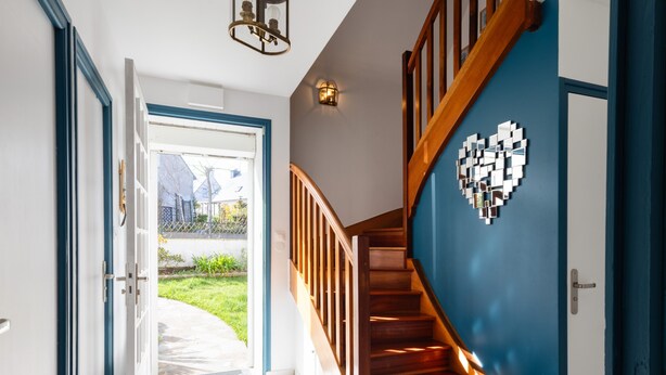 A staircase with wooden steps and a blue wall, leading to a door with a geometric pattern. - Holiday Home 'L'escale Kénanaise' with Private Garden and Wi-Fi (Saint-Quay-Perros)