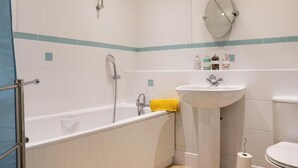 A bathroom with a bathtub, a sink, a toilet, and a shower. - Contractors/family - Parking - Wifi - Sleeps 6 (Milton Keynes)