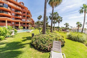 A hotel with a pool, palm trees, and a chair in the garden. - 28 - Exclusive Modern Penthouse with Stunning Views & Pool, Benalmadena (Benalmádena)