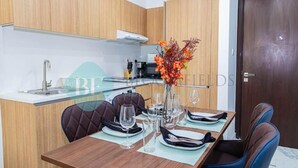 A modern kitchen with a dining area. - Bloomfields Iconic 1BR in Oasis Masd (Abu Dhabi)