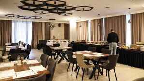 A conference room with multiple tables, chairs, and a buffet setup. - Hotel Karting (Mostar)