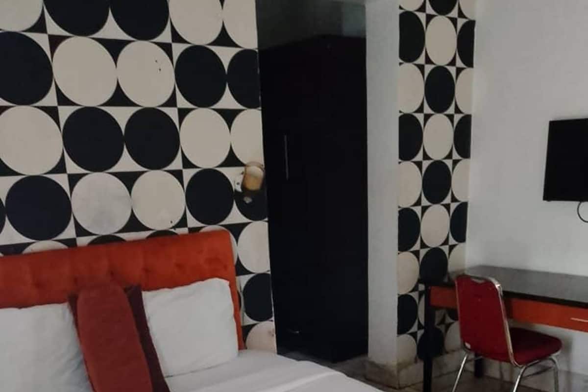 Hotellihuone, jossa on suuri sänky, työpöytä ja tuoli.
