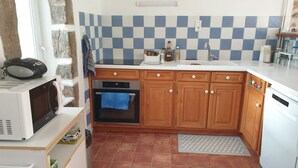 Cocina compacta equipada con microondas, horno y lavaplatos.