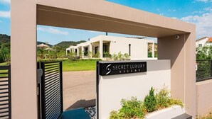 A modern villa entrance with a sign reading "Secret Luxury Villas." - Ioannina Secret Luxury Villas (Vounoplagia)