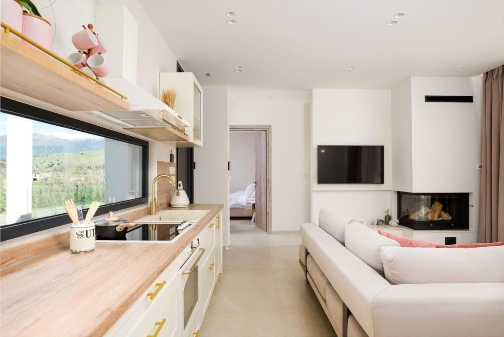 Een moderne keuken met een raam, een eethoek en een woonkamer met een open haard.