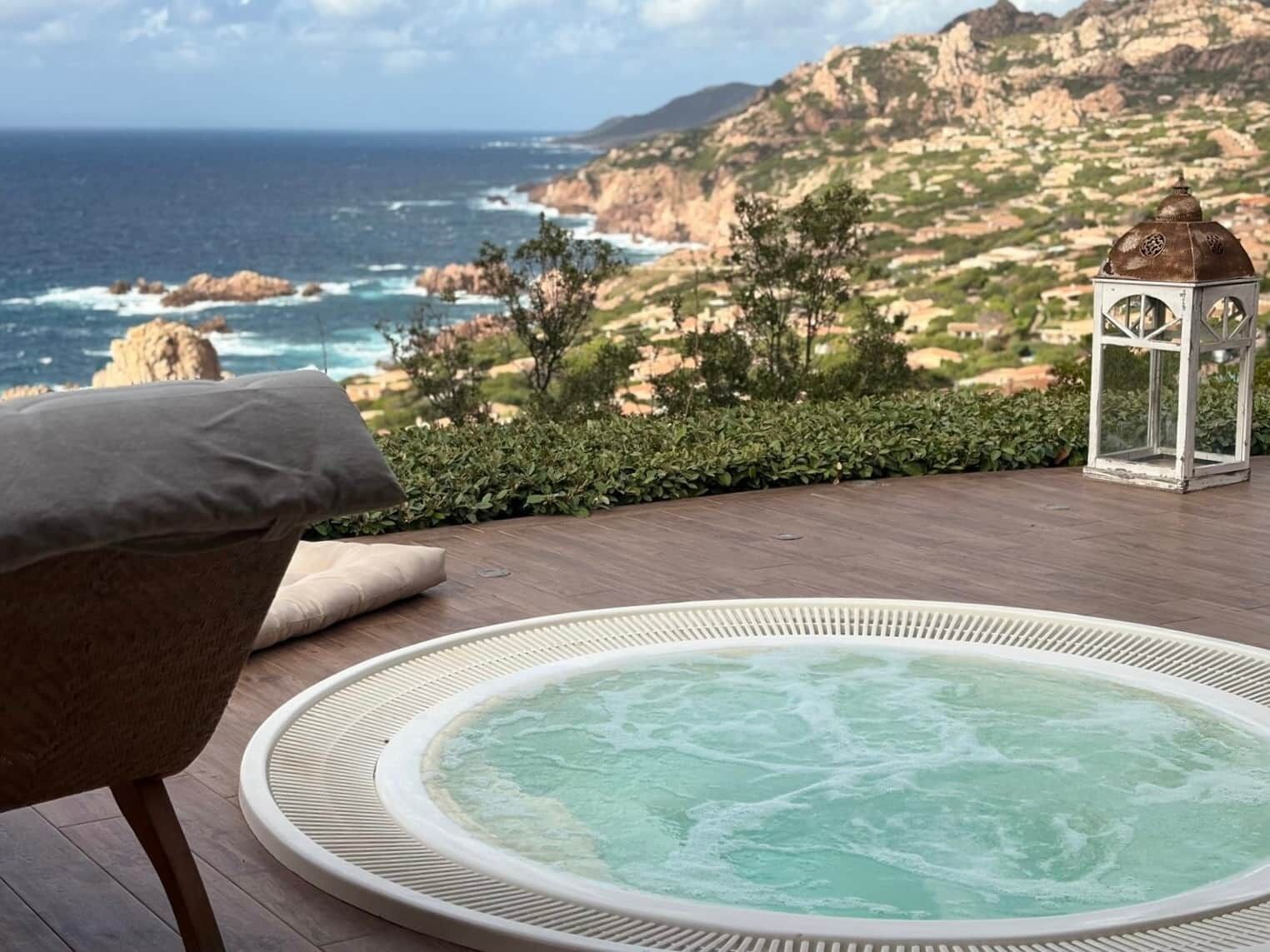 Un jacuzzi con vistas al océano y al paisaje rocoso.