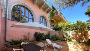 A patio with a table and chairs, a large umbrella, and a star-shaped decoration on the floor. - Captain Howard House
 Blackburn Santa Teresa Gallura (Santa Teresa Gallura)