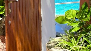 A wooden door leading to a balcony with a view of a blue sea and rocky outcrops. - Captain Howard House
 Blackburn Santa Teresa Gallura (Santa Teresa Gallura)