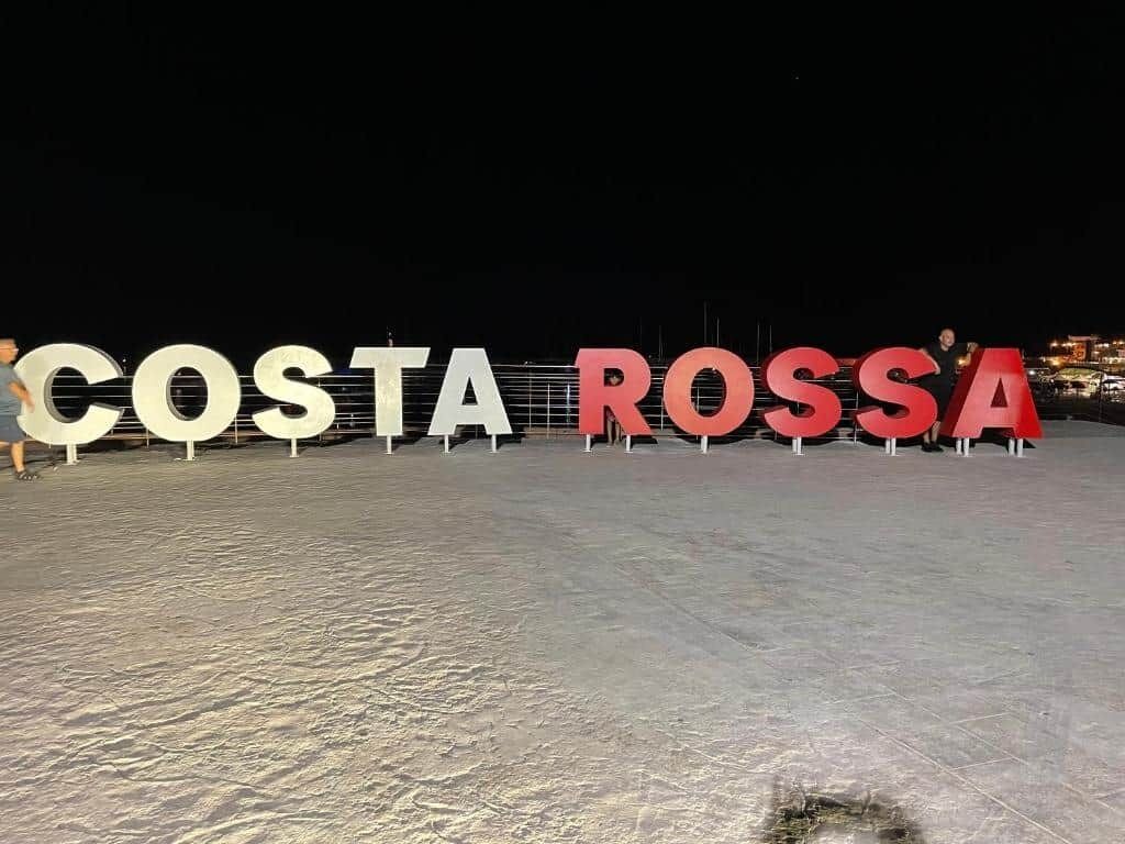 De grandes lettres lumineuses, formant le mot « COSTA ROSSA », sont disposées sur une surface plane.