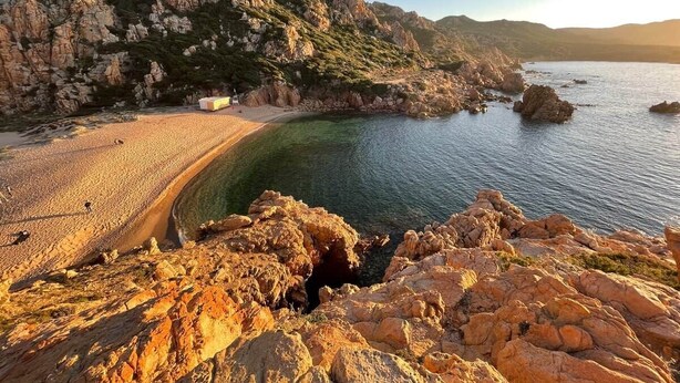 A coastal landscape with rocky terrain, a sandy beach, and clear water. - Domus Ninni - Charm of Gallura (Costa Paradiso)