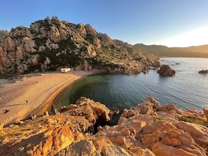 A coastal landscape with rocky terrain, a sandy beach, and clear water. - Domus Ninni - Charm of Gallura (Costa Paradiso)