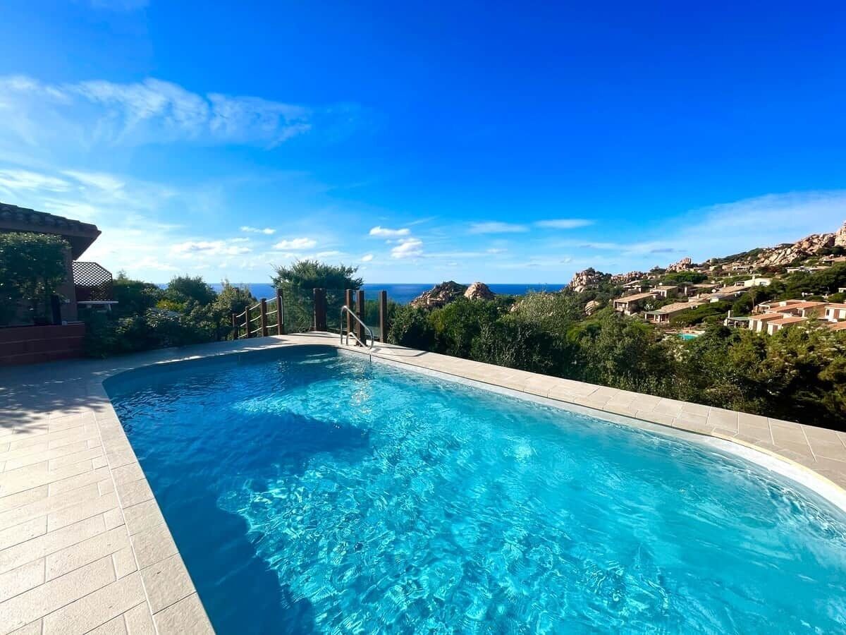 A swimming pool with a clear view of the surrounding landscape and distant buildings.