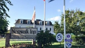 Ein Schild des Norwalk Inn mit einer US-amerikanischen Flagge und einer blau-weißen Flagge.