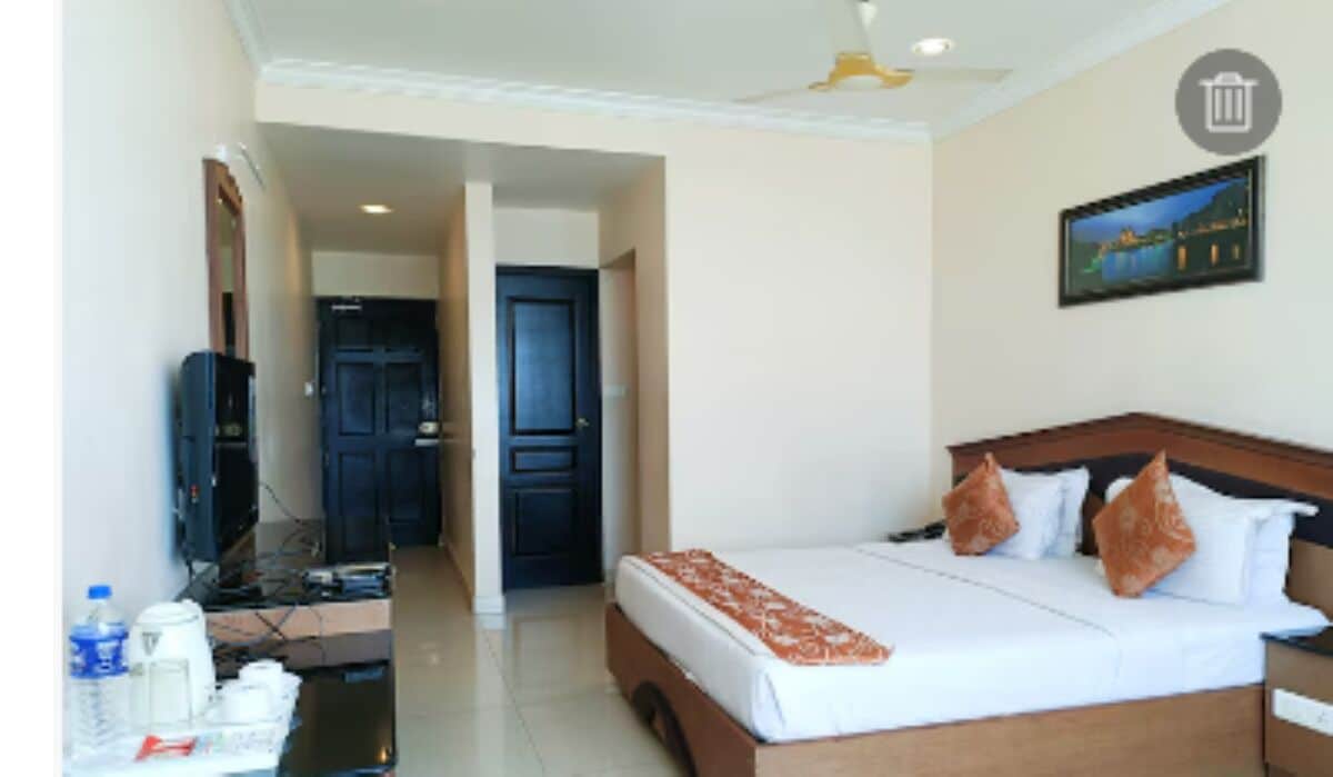 A hotel room with a bed, a television, a desk, and a nightstand.