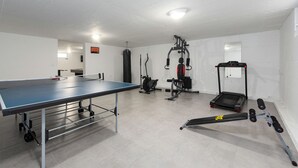 A gym with a ping pong table, exercise equipment, and a treadmill. - Villa Descansa Zadarvillas (Nin)