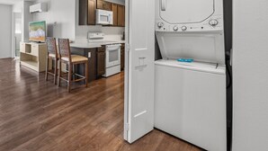 A compact kitchen with a microwave, stove, and a built-in washer-dryer unit. - 2BR ¼ mi to Kam 1 Beach, Pool, Hot Tub, Gym, BBQ (Kihei)