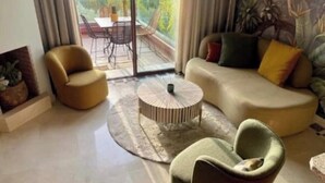 Una sala de estar con un sofá, un sillón y una mesa de centro redonda.