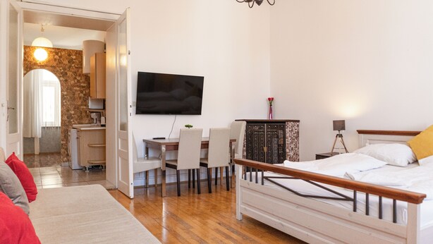 A bedroom with a bed, a TV, a desk, and a dining area. - Spacious 2BR Apartment Long Stay Vienna (Vienna)