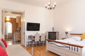 A bedroom with a bed, a TV, a desk, and a dining area. - Spacious 2BR Apartment Long Stay Vienna (Vienna)