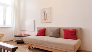 A modern living room with a sofa, a small table, and a painting on the wall. - Spacious 2BR Apartment Long Stay Vienna (Vienna)