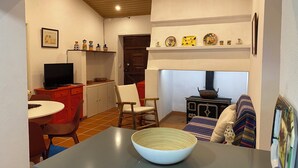 A compact kitchen with a dining area, a television, and a stove.