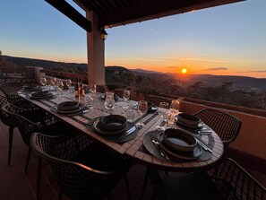 Un espacio de comedor al aire libre con una mesa dispuesta para una comida, con vistas a un paisaje pintoresco.