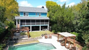 Una casa de dos pisos con un amplio balcón y piscina.