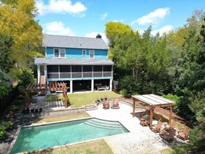 Ein zweistöckiges Haus mit einer großen Terrasse und einem Swimmingpool.