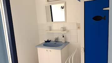 Un bagno con lavandino, specchio e una porta blu.