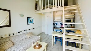 A compact living space with a bunk bed, kitchenette, dining area, and a sofa. - Apartment with sea view - 4 guests (Fouras)