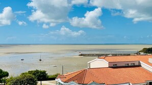A coastal view with a beach, a pier, and buildings with red-tiled roofs. - Apartment with sea view - 4 guests (Fouras)