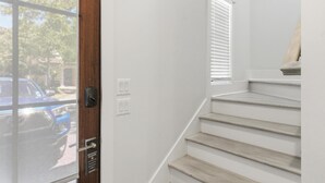 Een trap met een houten afwerking, een deur met een privacybericht, en een raam met jaloezieën.
