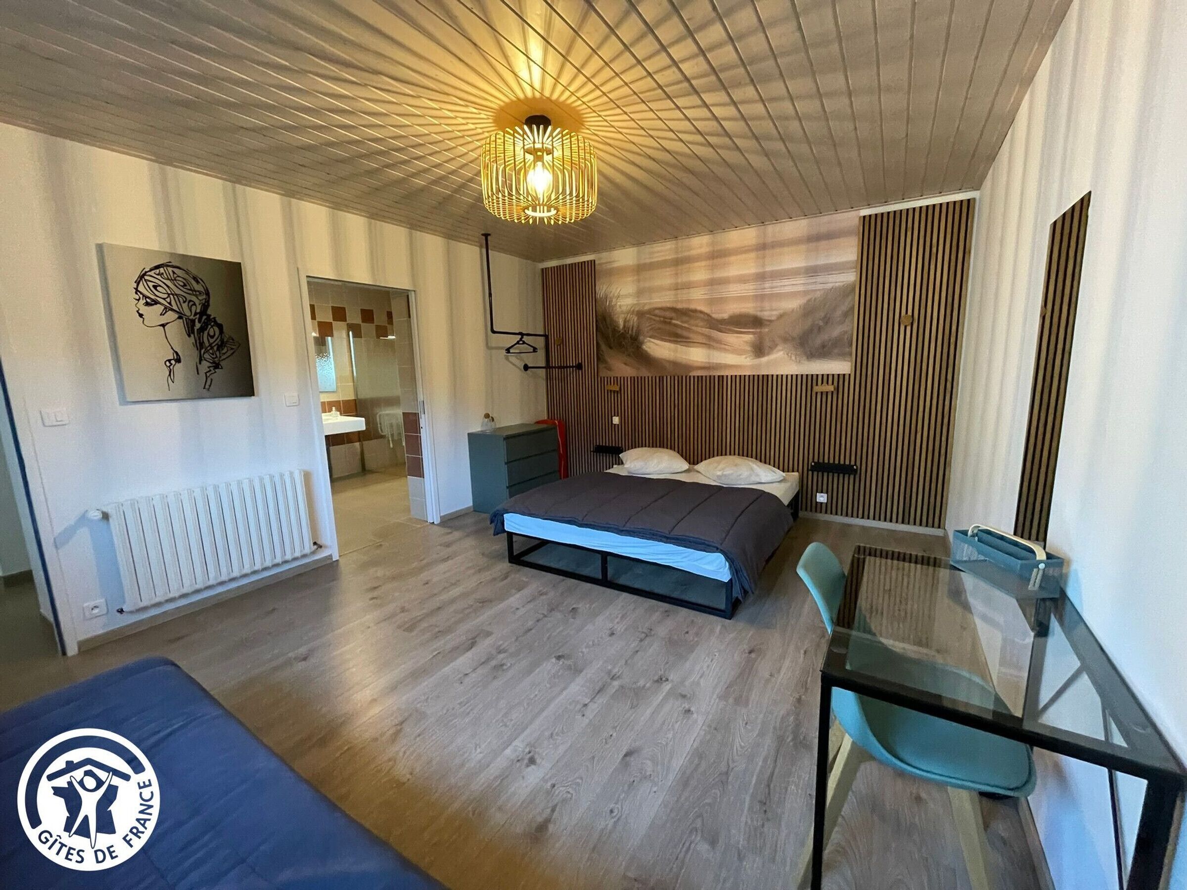 Een moderne slaapkamer met een bed, nachtkastje en een glazen tafel met stoelen.