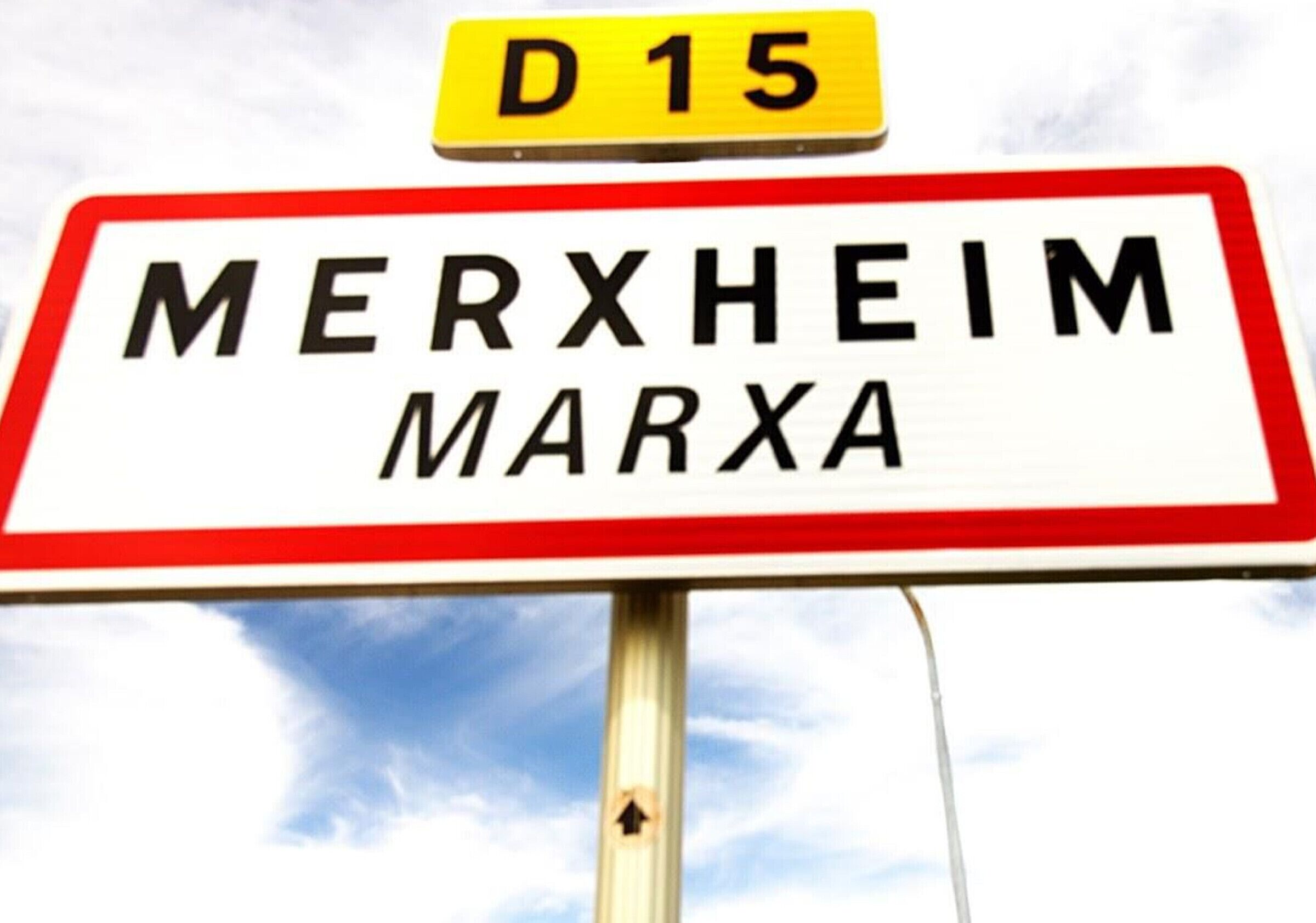 Un panneau de signalisation routière indiquant « MERXHEIM MARXA » et « D 15 ».