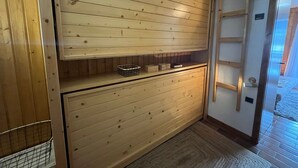A wooden interior with a built-in shelf, a ladder, and a basket. - Charming 2-room apartment by Lake Vonnes with terrace (Châtel)