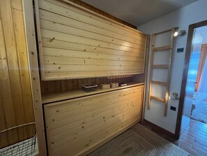A wooden interior with a built-in shelf, a ladder, and a basket. - Charming 2-room apartment by Lake Vonnes with terrace (Châtel)